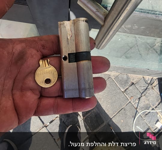 מנעול גליל ומפתח ביד של מנעולן